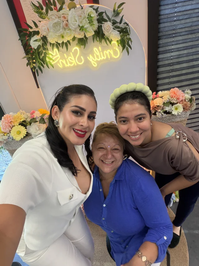 Three attendees smiling together at the event.