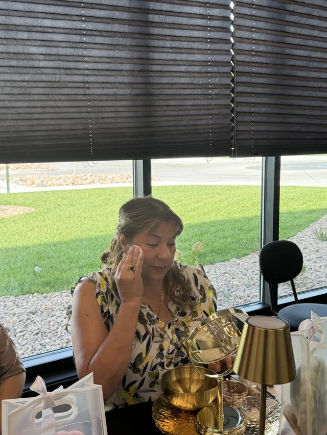 A participant practicing skincare with a cotton pad and mirror.